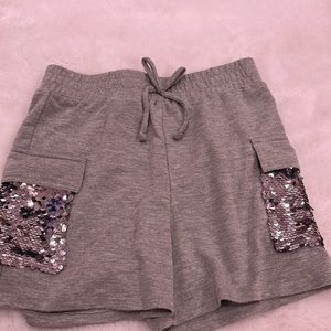 Grey shorts with sparkles/sequins on the pockets and a non working tie for show